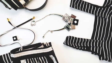 Clothes and accessory collection. Striped female hat, earring, necklace, black and white purse with...