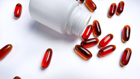 Food supplement oil filled capsules and medical bottle on white background. Capsule pills rotatingの写真素材