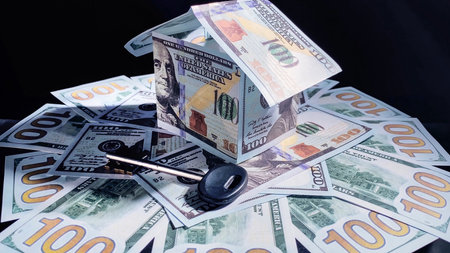 House made of American currency banknotes and key on money background. Mortgage and savings concept. selective focus.の写真素材
