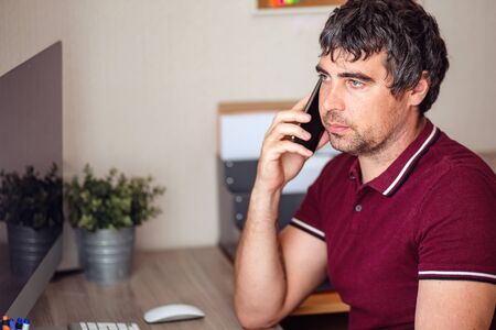 A modern young person works remotely from home. Young man video conference via computer. Home...