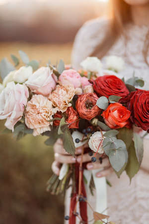 Beautiful delicate wedding bouquet in the hands of the brideの写真素材