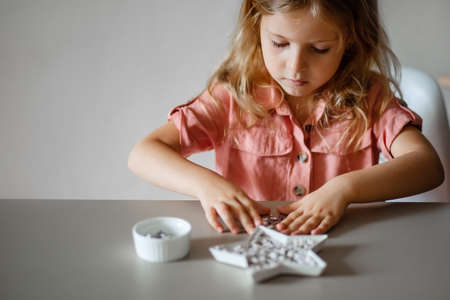 cute little blonde girl is engaged in creativity doing craftsの写真素材