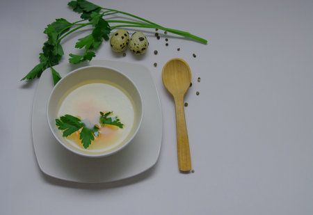 Diet chicken broth in a white bowl on a light backgroundの写真素材