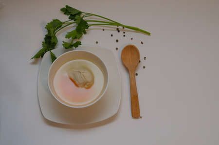 Diet chicken broth in a white bowl on a light backgroundの写真素材