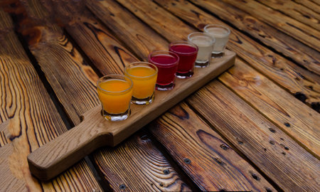 A set of colorful alcoholic tinctures on berries and fruits on a wooden backgroundの写真素材