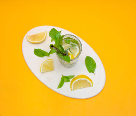 Summer refreshing Mojito cocktail on a light background. Drink with mint, lemon and ice