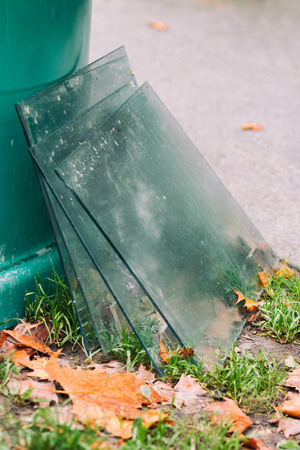 Window glass by the recycle bin, thrown out in the trashの写真素材