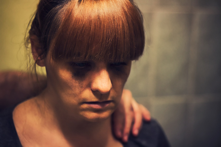 Comforting hand on a shoulder of crying abused womanの写真素材