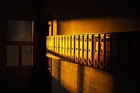 Raw of metal mailboxes in a lobby, sunset lightの写真素材