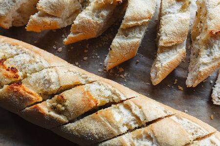 Two freshly baked loafs of baguette sliced and ready to eat