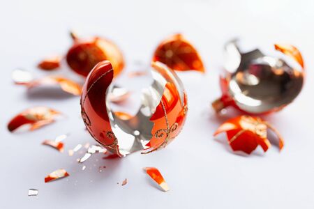 Bright orange, glass Christmas baubles broken, scattered fragments on a white backgroundの写真素材