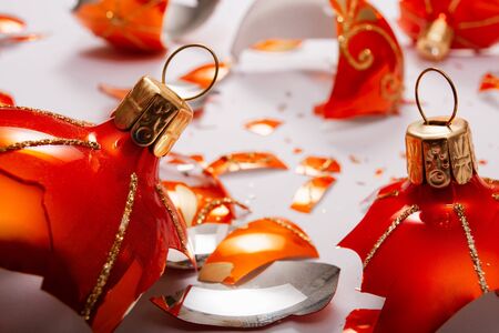 Bright orange, glass Christmas baubles broken, scattered fragments on a white background