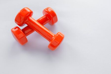 Couple of orange dumbbells on white background, copy spaceの写真素材