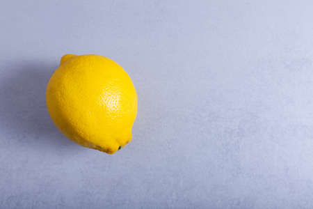 One fresh lemon on a neutral background