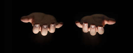 Male hands in the dark, palms facing upward, illuminated from  below, giving gesture