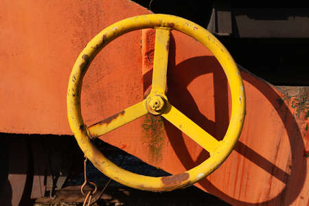 Yellow metal hand wheel, old and rustyの写真素材