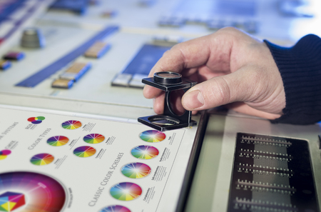 Young man in the process of offset printing and color correctionの写真素材