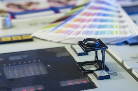 Color management in printing process with magnifying glass and color swatchesの写真素材