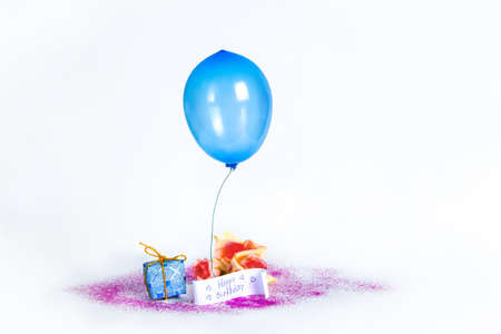 Lonely little balloon and a small gift on a white background. Miniatures. Postcard.の写真素材