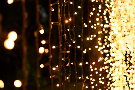 Festive garlands with yellow lights in perspective.の写真素材