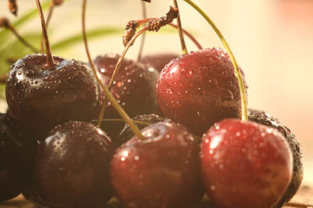Cherry berries covered with water droplets. The berries are on a bamboo substrate. Close-up.