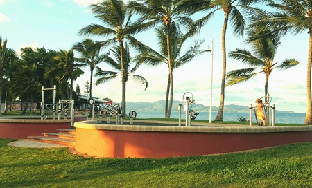 Children play on gym equipment on the seashore, in Townsville  Australia. Magnetic Island in backgrnの素材