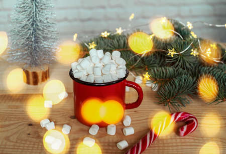 Hot chocolate cup with marshmallows with christmas lights on the background, christmas vibesの写真素材