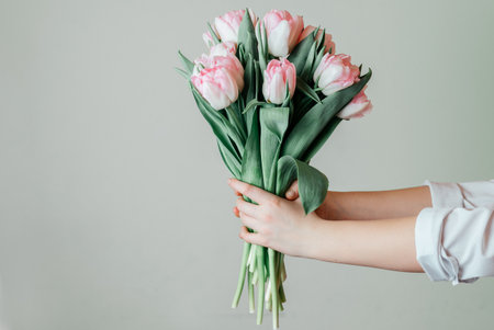 Hands holding bunch of pink tulips on green background, Womens day greeting cardの写真素材