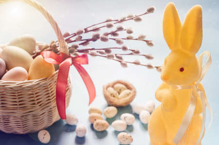 Yellow Easter bunny with a basket full of Easter eggs and pussy willow branches. Happy Easter...