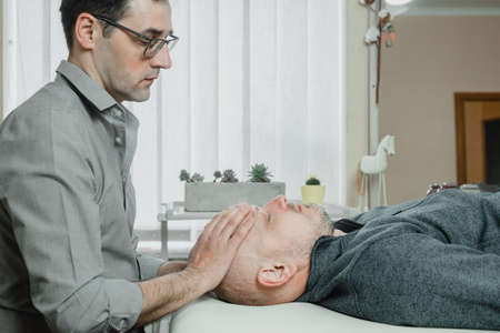 CST practitioner relieves compression in the bones of the head, sacrum, and spinal column using...