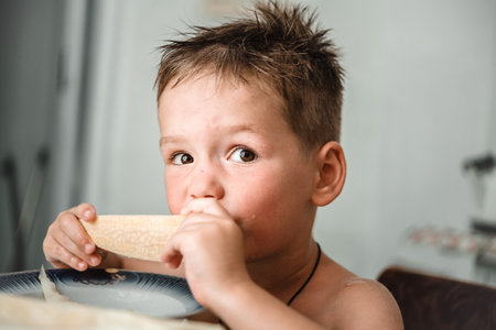 Cute little boy eating a slice of fresh melonの写真素材