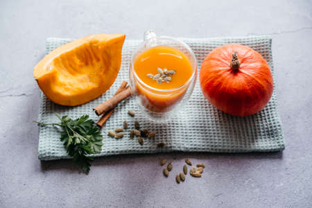 A glass of fresh pumpkin smoothie decorated with a leaf of parsleyの写真素材