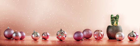 Christmas cactus with pink and coral baubles on pinkish orange background for mock up template...