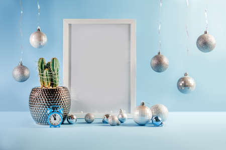 Christmas mock-up with white frame, cactus and Christmas balls on blue background