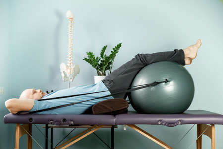Rotation exercises on the fitness ball with resistance bands in constructive rest positionの写真素材