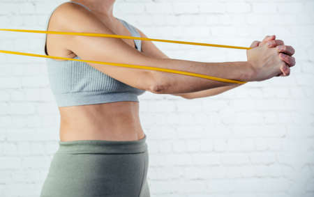 A woman performs exercises with resistance bandの写真素材
