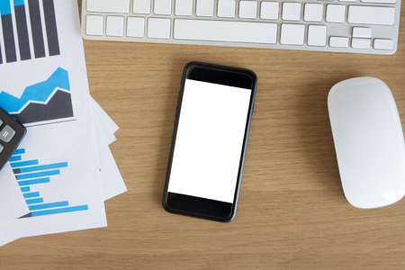 Office desk table with blank screen smart phoneの写真素材