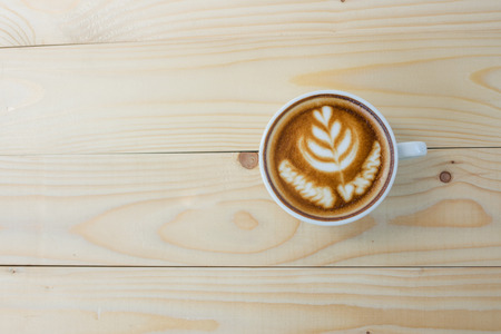 Hot art Latte Coffee in a cup on wooden tableの写真素材