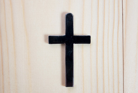 Necklace with silver cross on wooden tableの写真素材