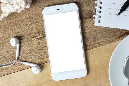 Top view of blank screen smart phone on on wood desk work.の写真素材