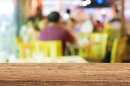 Wood table top with blurred people in cafe as background  for display productsの写真素材