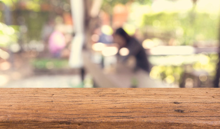 Wood table top with blurred people in cafe as background with vintage toneの写真素材