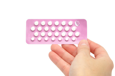 Tablets (Birth Control Pills) with woman hand, isolated on white backgroundの写真素材