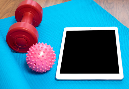Blue yoga mat,dumbbell with tabletの写真素材