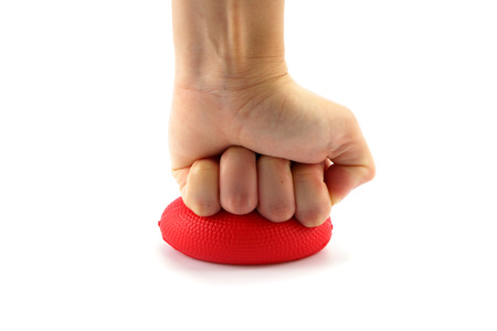 Hand squeezing a stress ball  on white backgroundの写真素材