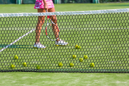 The girl and the tennis balls on the Court.の写真素材