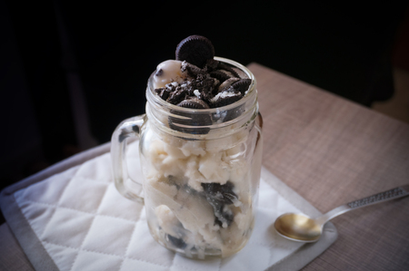 Ice cream topped with oreo type cookies in mason jarの写真素材