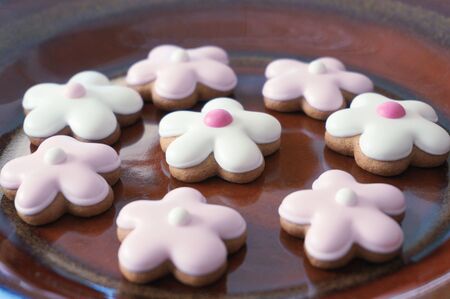 Ginger cookies flower shape on brown ceramic plate
