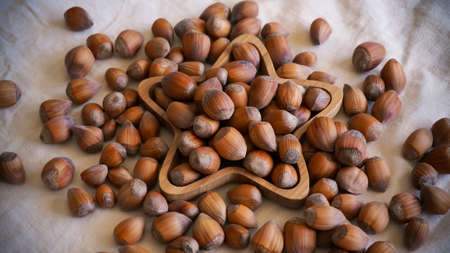 Raw hazelnuts on bamboo star shape plate