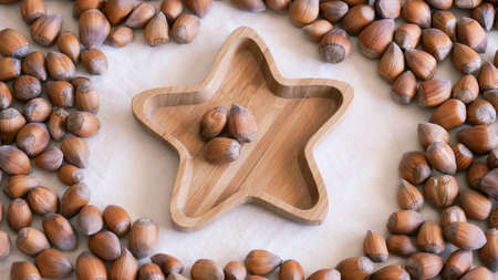 Raw hazelnuts on bamboo star shape plate